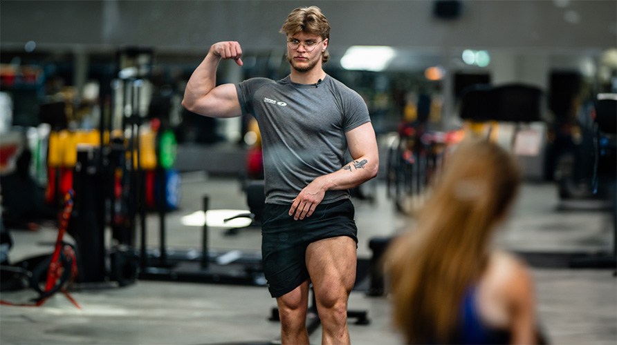 Kille i gymmilj� som sp�nner sina ben och armar.